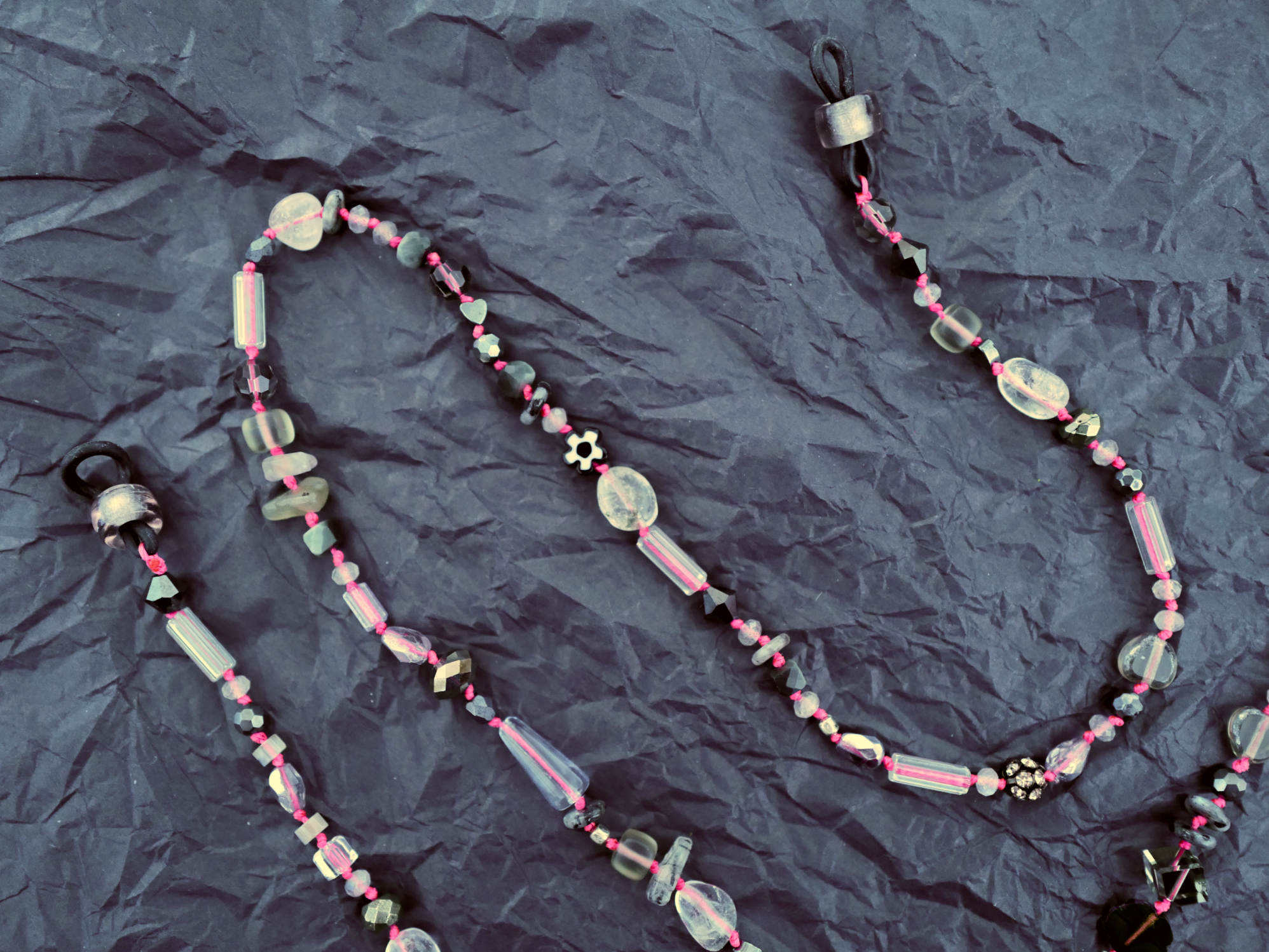 Smoke and pink glasses chain on dark paper